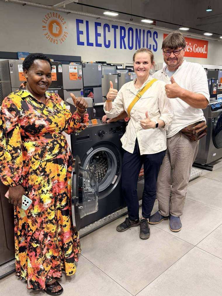Serah, Christin und ihr Vater Matthias mit Daumen hoch vor der neuen Waschmaschine im Laden