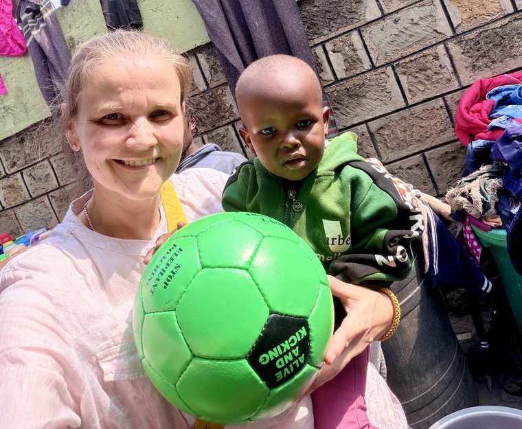 Christin mit einem kleinen Jungen und einem grünen Fußball