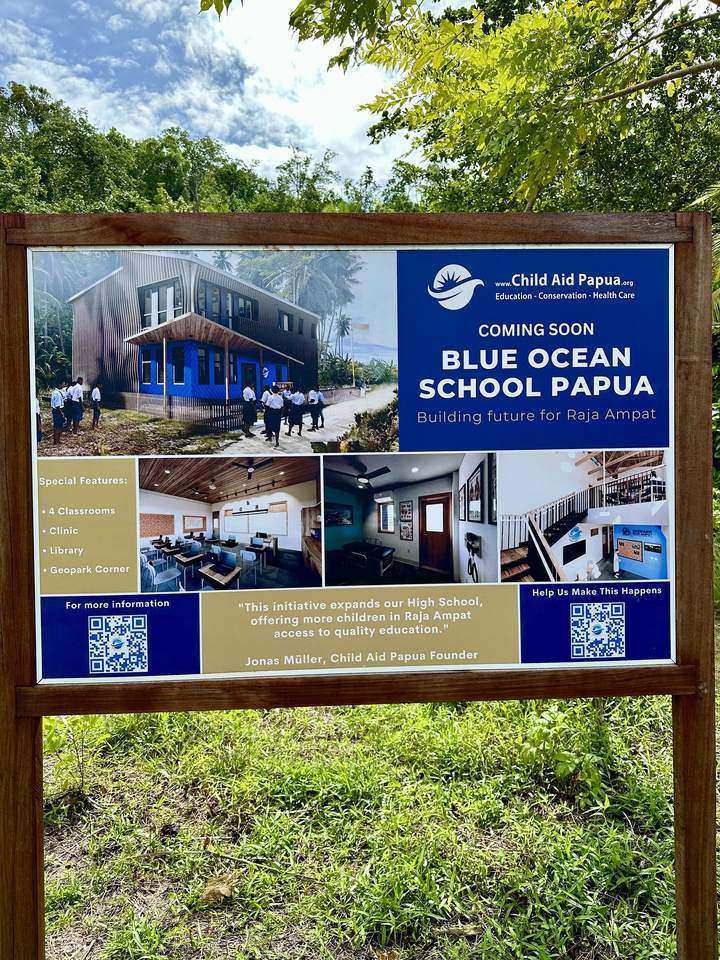 Bautafel der Blue Ocean School Papua mit Entwurfsbildern, aufgenommen 2024